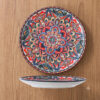 An upscale commercial table setting featuring a vibrant bohemian mandala ceramic dessert plate inside a themed bistro.