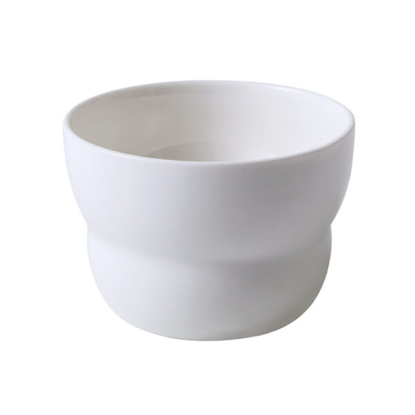 ceramic-coffee-cup-and-dessert-plate Top view of an organic-shaped ceramic dessert plate paired with a handless wavy coffee cup.