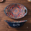 An elegant restaurant table setup featuring the bohemian mandala oval ceramic boat dish as a centerpiece sharing bowl.