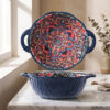 Close-up view of the dark blue fluted wave relief textured exterior and sturdy handle of a bohemian mandala round ceramic dish.