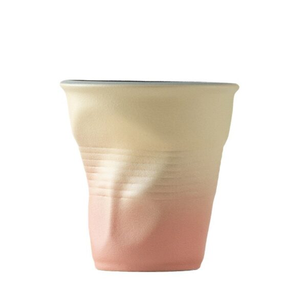 gradient-matte-wrinkled-ceramic-mugs Side view of wrinkled ceramic mugs in amber coral and teal gradient glaze options arranged on minimalist display blocks.