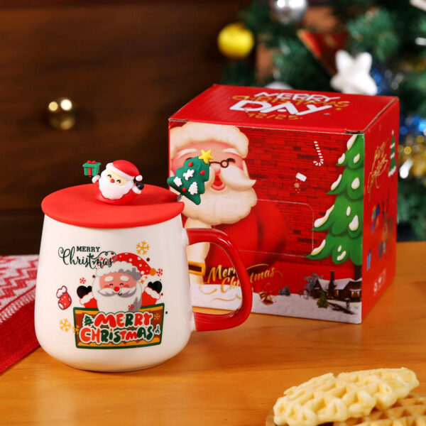holiday-themed-ceramic-mugs-wholesale Display of holiday-themed ceramic mugs on a wooden surface with a decorated Christmas tree in the background.