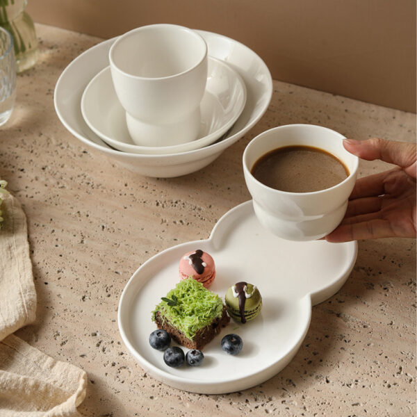 modern-porcelain-coffee-saucer-tray A person holding a modern porcelain coffee saucer tray served with matcha cake and macarons.