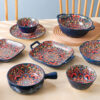 An open table arrangement of a wholesale bohemian dinnerware set showing mandala pattern ceramic bowls with handles and baking dishes.