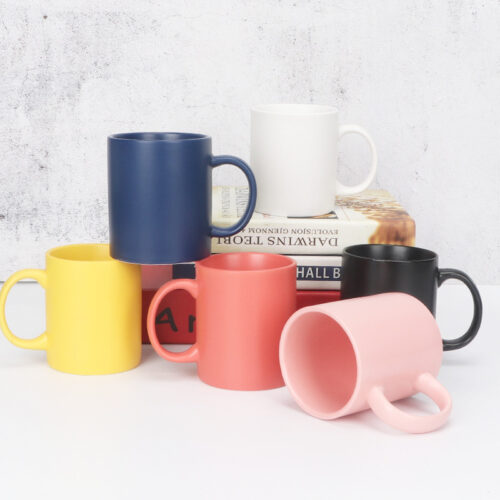 wholesale-matte-ceramic-mugs Wholesale classic matte ceramic mugs in multiple solid colors stacked on a white surface for promotional supply.