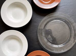 Commercial tableware comparison showing ceramic, melamine, and tempered glass plates side by side.