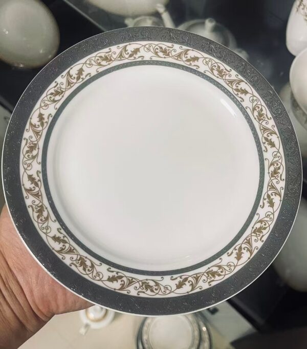 European Gold Rim Ceramic Plate - Close-up Detail Close-up of European floral porcelain plate with charcoal gray rim and gold scrollwork pattern detail