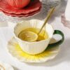 Flower ceramic cup with green handle and glossy glaze detail