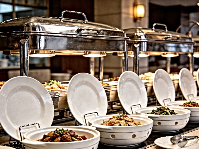 ceramic buffet tableware displayed on stainless steel chafing stands in a commercial restaurant buffet setup