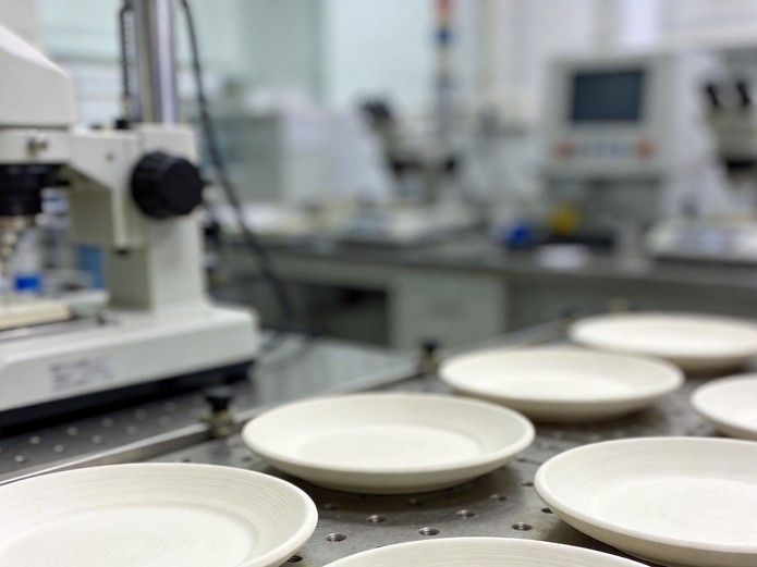 white ceramic plates being tested on laboratory equipment for lead cadmium migration testing