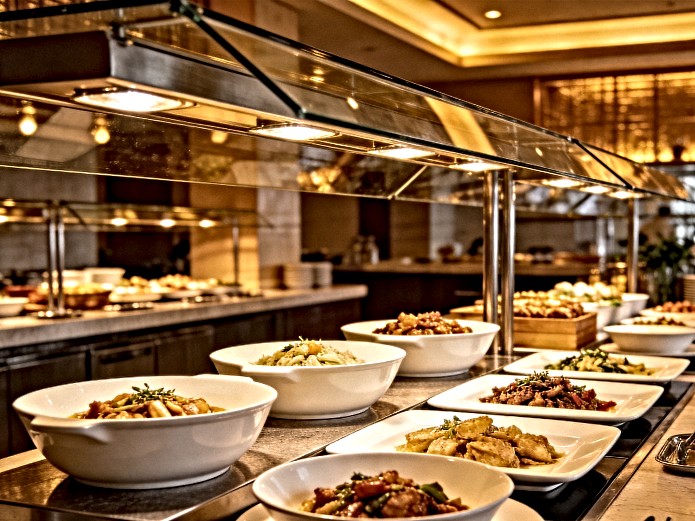 ceramic serving bowls and platters arranged on a modern buffet counter for foodservice display