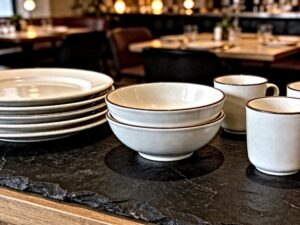 ceramic tableware collection displayed on dark slate countertop for hospitality buyers