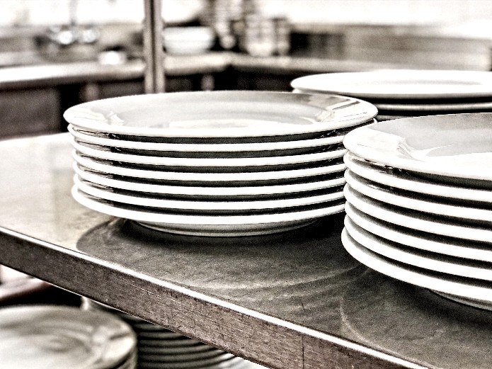 stackable ceramic buffet plates on stainless steel shelving for commercial catering operations
