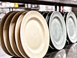 ceramic color consistency comparison showing matched and mismatched restaurant tableware batches on a stainless steel counter