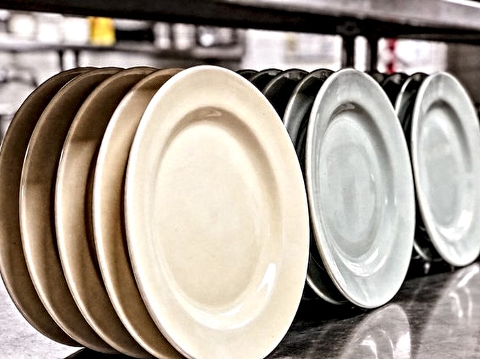 ceramic color consistency comparison showing matched and mismatched restaurant tableware batches on a stainless steel counter