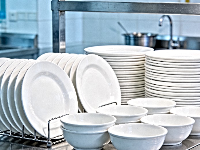 ceramic tableware for hospitals displayed on stainless steel serving counter in healthcare foodservice setting