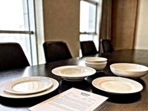 ceramic tableware purchase contract document displayed on conference table with white porcelain plates and bowls for B2B buyers