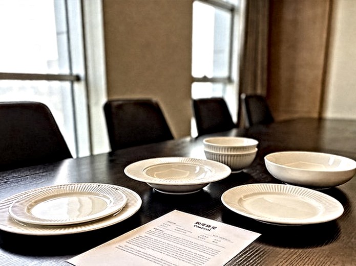 ceramic tableware purchase contract document displayed on conference table with white porcelain plates and bowls for B2B buyers