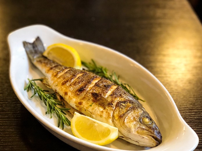 ceramic fish serving platter with grilled whole fish and lemon garnish for commercial seafood dining