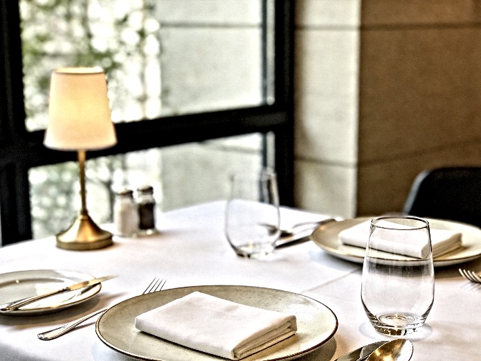 ceramic tableware for fine dining elegantly arranged on white linen for upscale restaurant service