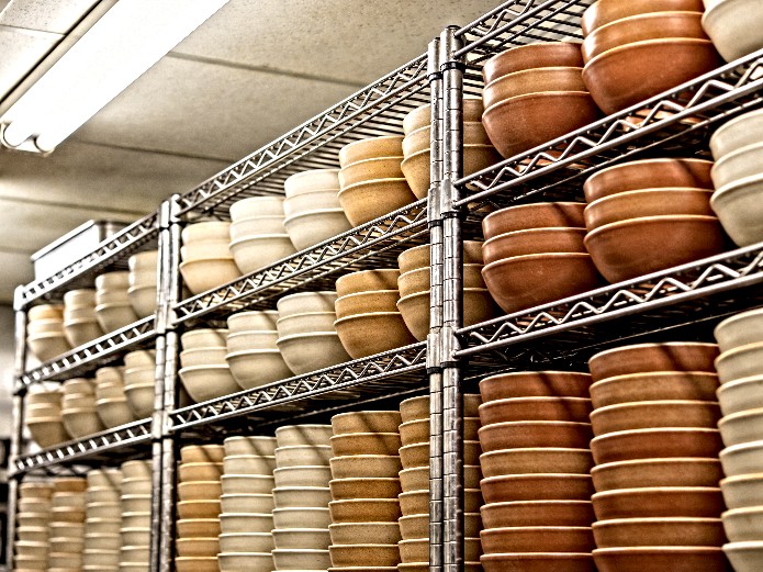 stacked ceramic ramen bowls on commercial kitchen shelving