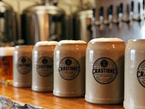 ceramic tableware for brewery taprooms displayed on a rustic wooden bar with craft beer