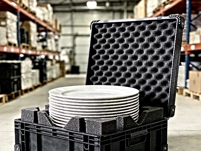 stack of durable ceramic plates packed in foam-padded transport crate for wedding rental company logistics