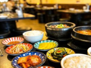 korean restaurant ceramic tableware with dolsot stone bowls and colorful banchan plates arranged for commercial dining