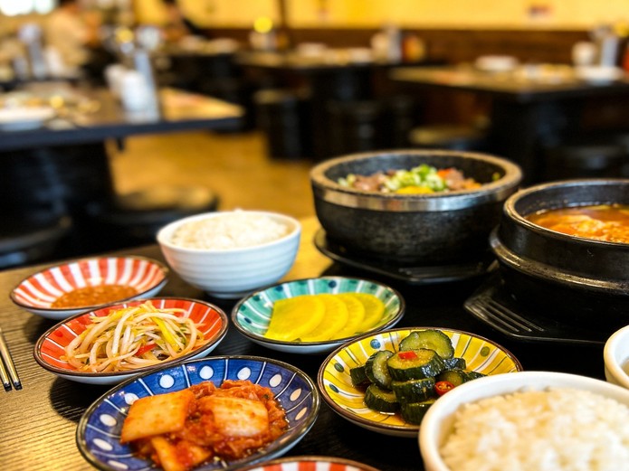 korean restaurant ceramic tableware with dolsot stone bowls and colorful banchan plates arranged for commercial dining