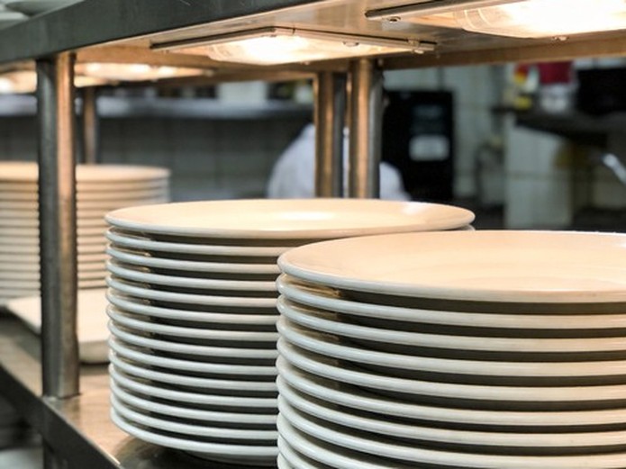 stacked ceramic plates in restaurant kitchen storage for commercial tableware sourcing