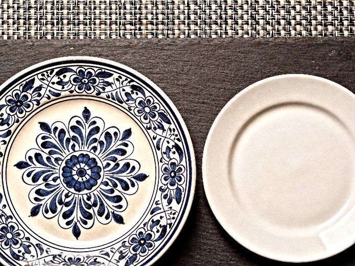 Talavera hand-painted ceramic plates compared to plain white commercial dinnerware for restaurant sourcing